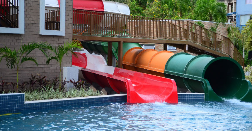 Saídas dos toboáguas vermelho e tubular laranja e verde chegando à piscina do Holandês Voador